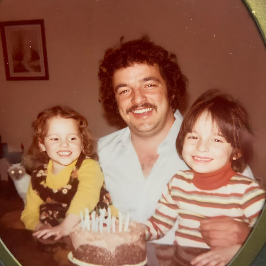 Leo Jeanveau smiling with two of his children