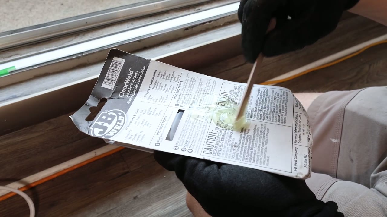 J-B Weld ClearWeld quick-setting epoxy mixed on its card with a stir stick