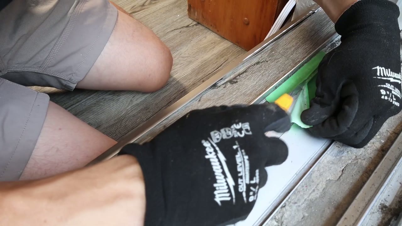 Utility knife slicing the epoxy edge clean as the painter's tape peels away