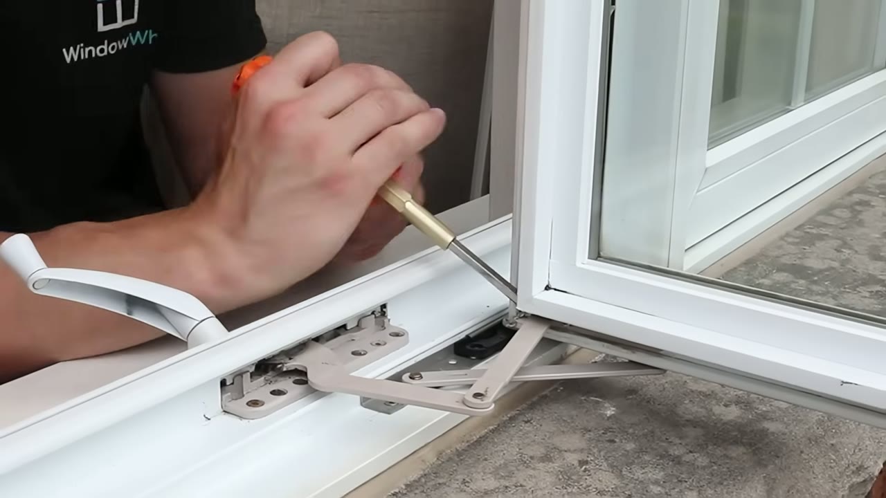 Flathead screwdriver levering the operator link arm off its stud bracket