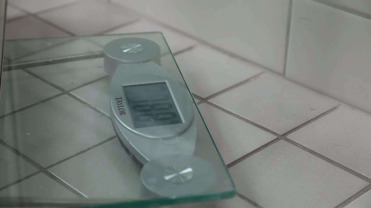 Bathroom scale during the sash weigh-in — the video's window reads 17 lb, so each side gets an 8 lb balance