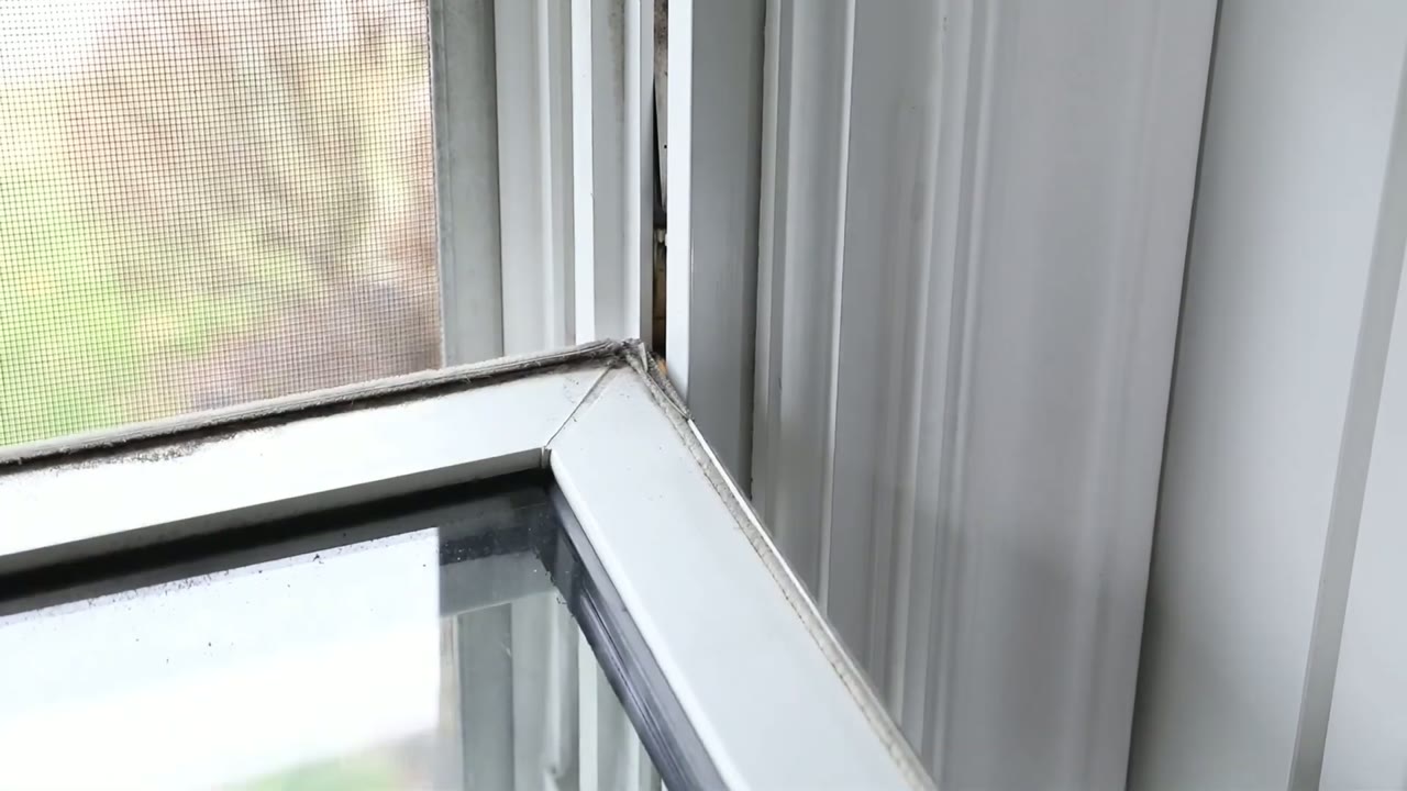 Upper sash corner going back in — seat the left pivot first, then lift the left side to drop the right pin home